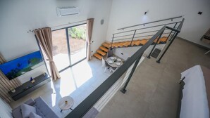 Un interior moderno con un sofá, una mesa de comedor y una escalera.