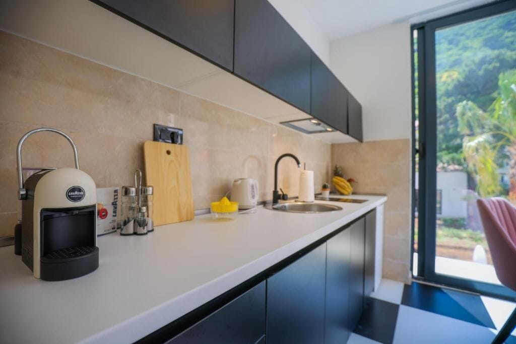 A modern kitchen with a coffee machine, a cutting board, and a sink.