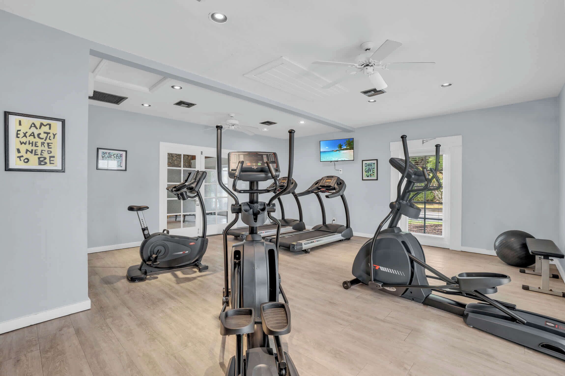 A home gym with treadmills, elliptical machines, and a stationary bike.