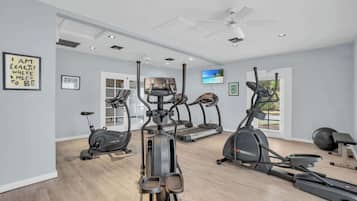 A home gym with treadmills, elliptical machines, and a stationary bike.