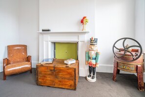 A room with a leather armchair, a wooden chest, a nutcracker, and a vintage toy train. - Steeple Peep Stay in the Historic Heart of Hobart (Hobart)