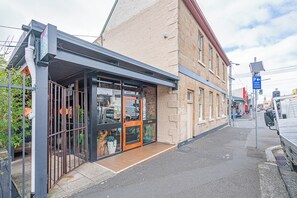 A building with a storefront, a pedestrian entrance, and a street view with vehicles and traffic lights. - Steeple Peep Stay in the Historic Heart of Hobart (Hobart)