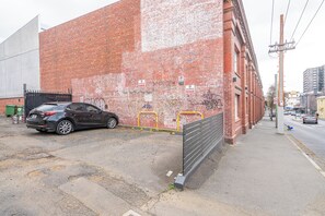 A black car parked in front of a red brick building with a no parking sign. - Steeple Peep Stay in the Historic Heart of Hobart (Hobart)