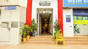 The entrance to Hotel JHD with a red facade, a reception desk, and potted plants. - Hotel JHD Luxury Stay Restro & Sky Bar (Udaipur)