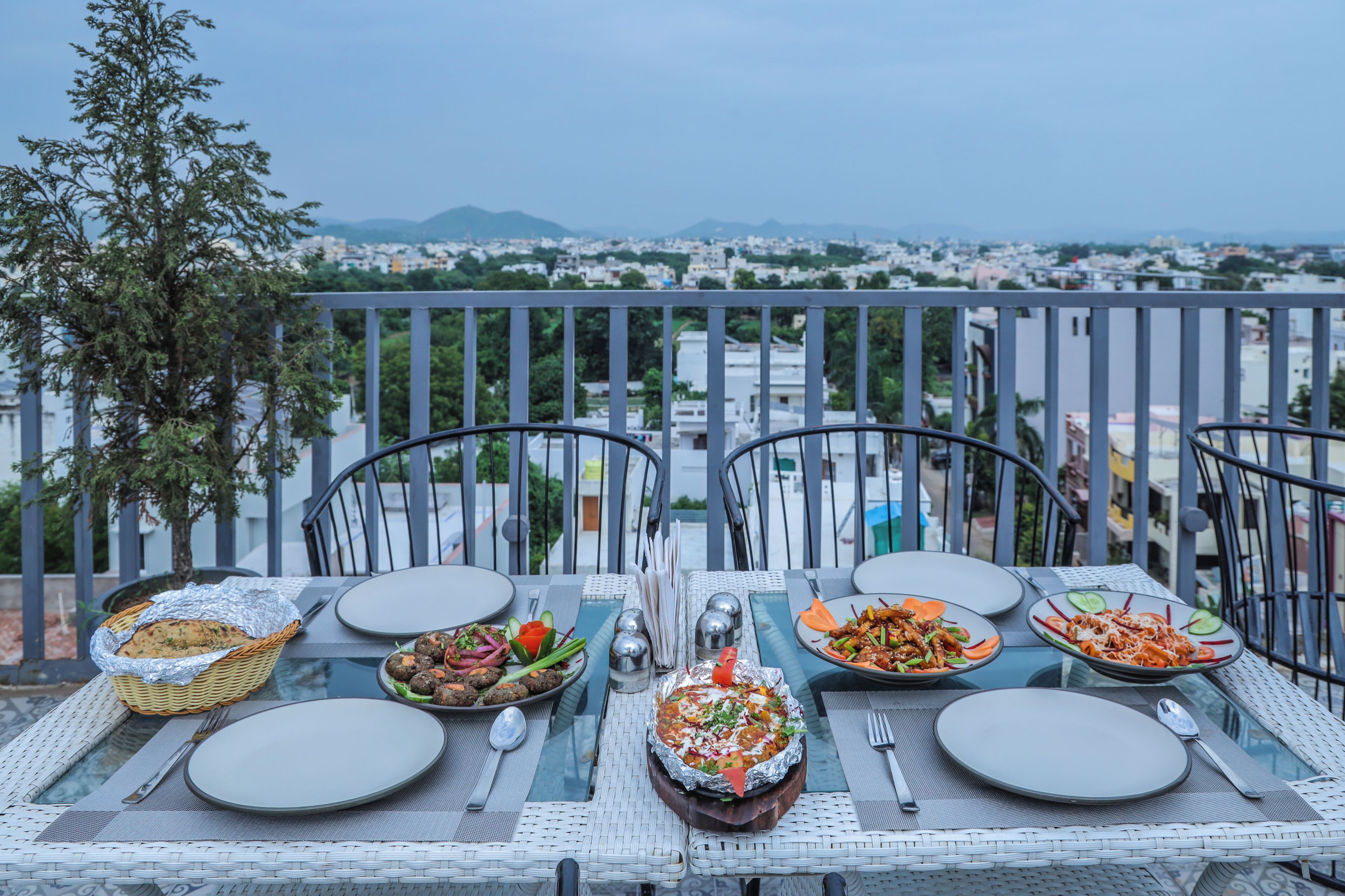A table set for a meal with a city view in the background.