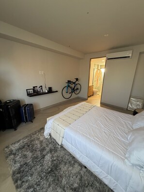 Een slaapkamer met een bed, een fiets en bagage.