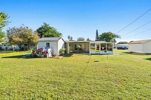 A single-story house with a covered porch and a small attached garage. - Beautiful Home in Vero Beach, 5 Min to Beach, Sleeps 6, King Bed (Vero Beach)
