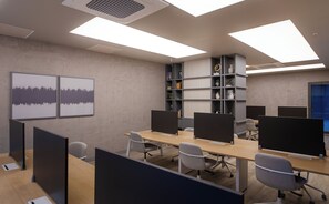 Un espacio de oficina moderno con cubículos, escritorios y sillas.