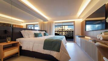 Une chambre moderne avec un grand lit, des tables de chevet, une vue sur la ville et un balcon.