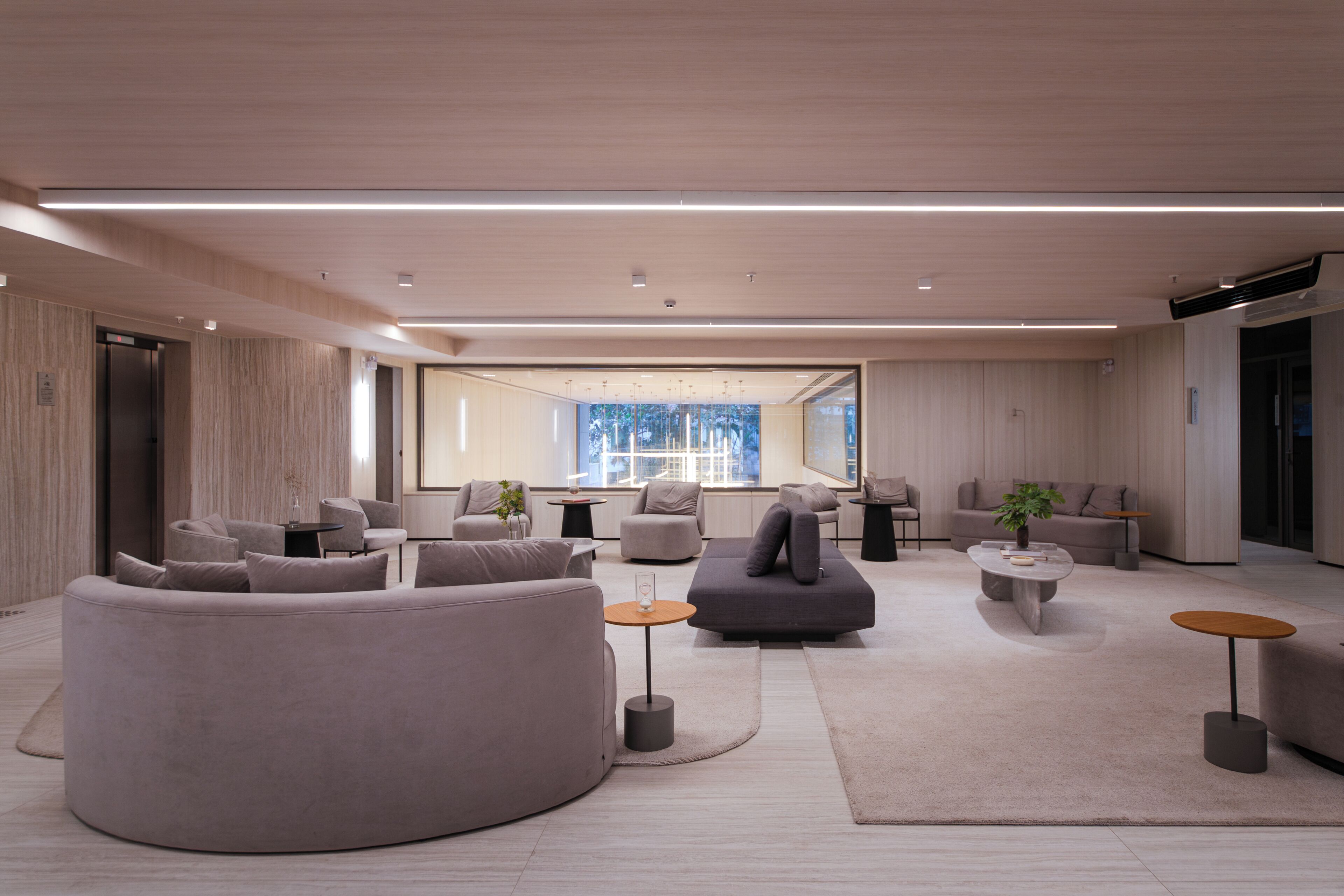 A modern living room with a large sofa, smaller seating, and a coffee table.