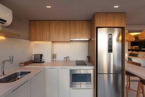 Una cocina moderna con microondas integrado, cafetera y refrigerador.