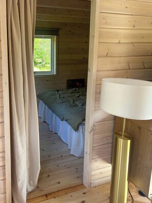 A wooden cabin room with a bed, a window, and a lamp. - Country retreat on Håtö near sea and fishing (Stockholms län)