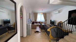 Sala de estar con sofá, televisor y dispensador de agua.