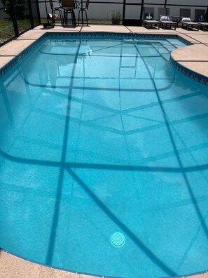 A rectangular swimming pool with a tiled edge, surrounded by a patio area with outdoor furniture. - 3-bedroom family friendly with pool in wonderful Largo just minutes to beaches (Largo)