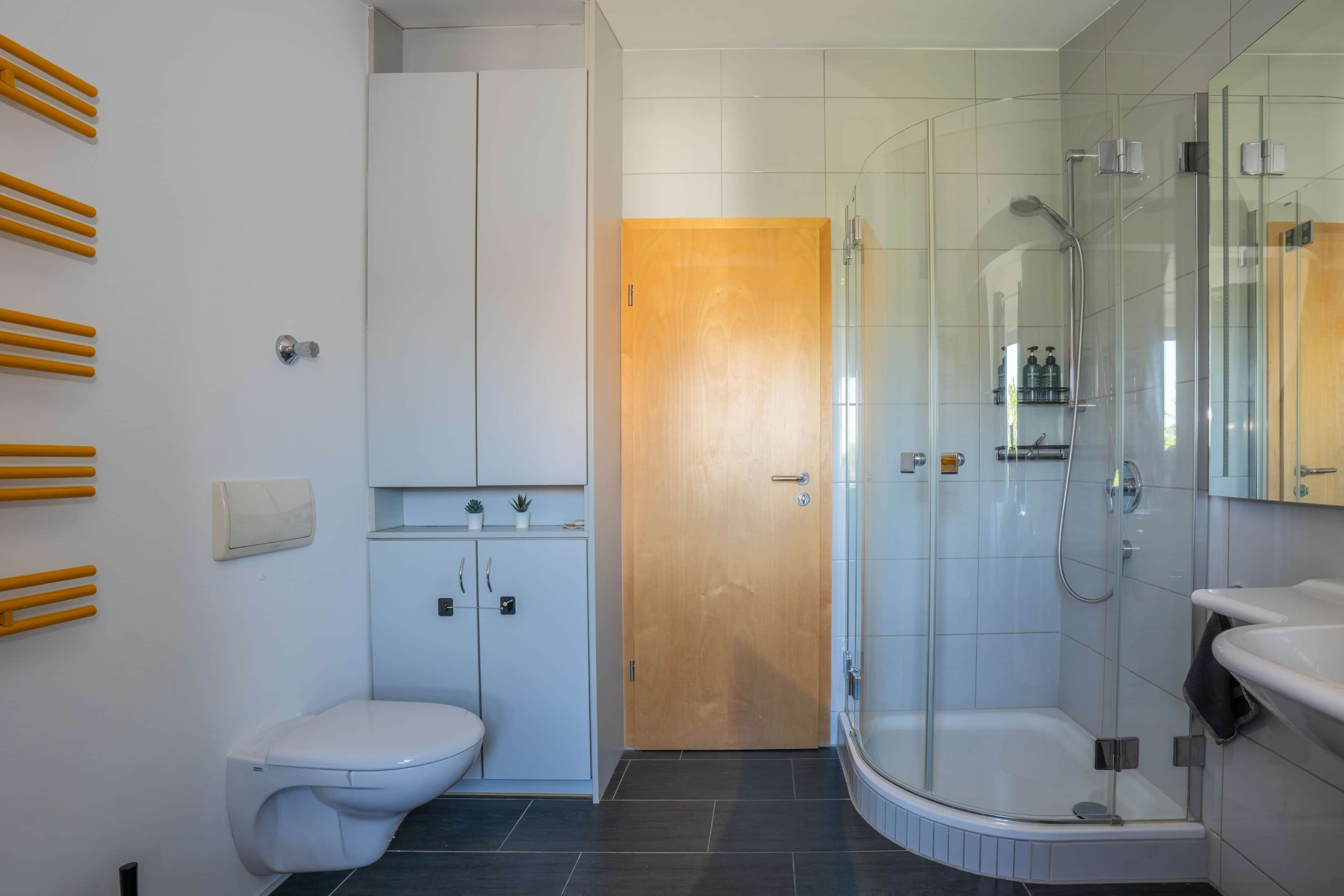 Ein modernes Badezimmer mit Toilette, Duschkabine und Waschbecken.