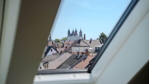 A view through a skylight of a cityscape with traditional buildings and a prominent church with multiple spires.
