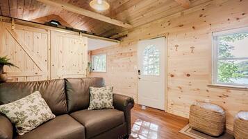 Un intérieur en bois avec un canapé en cuir, une porte et une fenêtre.