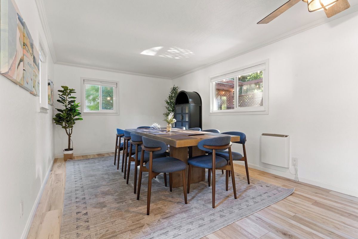 A dining area with a wooden table and blue chairs, a potted plant, and a radiator.