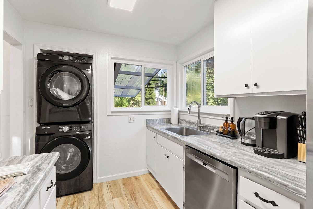 A compact kitchen with a washing machine, a coffee maker, and a dishwasher.