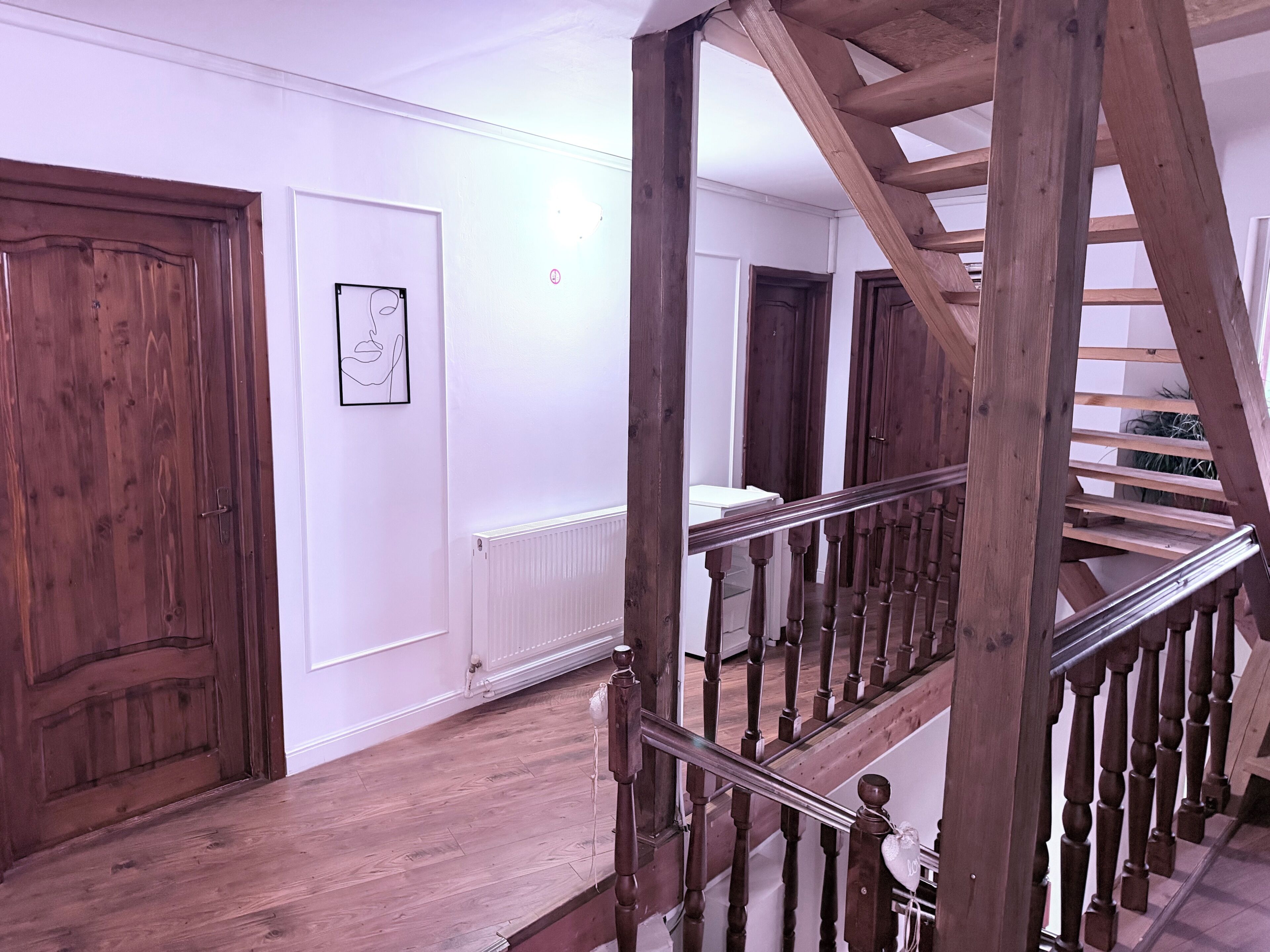 Eine Holztreppe mit Geländer, die zu einer oberen Etage führt.