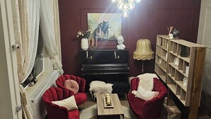 A living room with a fireplace, red sofas, a coffee table, and a bookshelf.