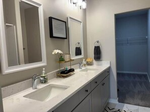 A bathroom with two sinks, a large mirror, and a shower area. - 3bed 2 bath with King master Sycamore (Sycamore)