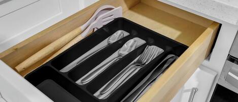 A drawer with utensils including a fork, knife, and spoon.