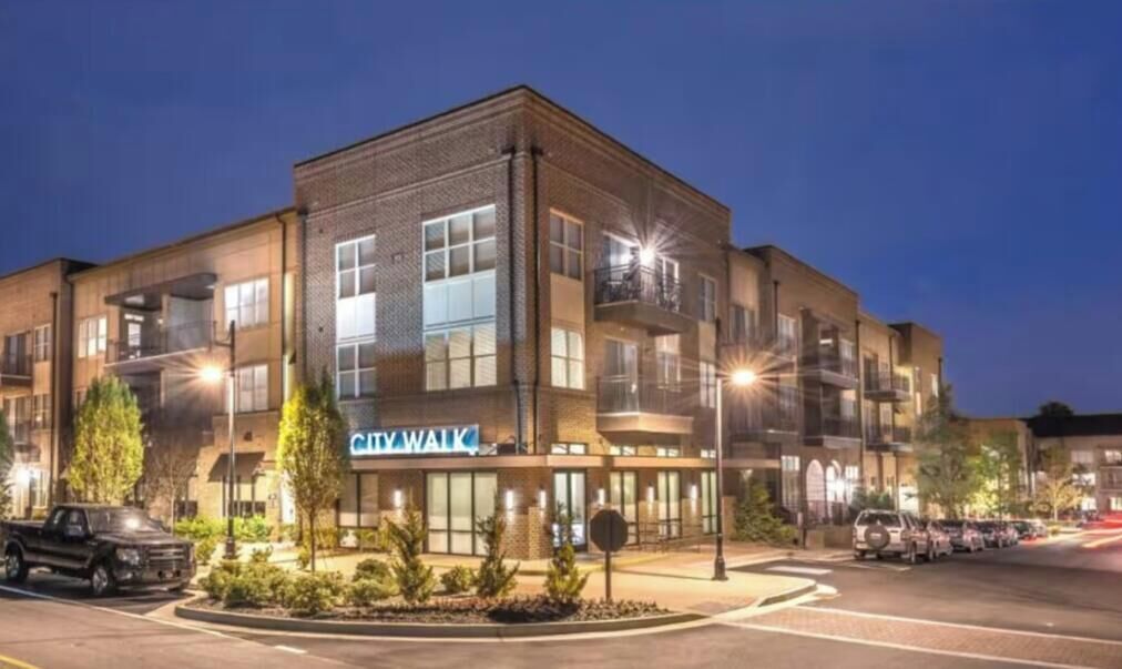 A multi-story building with a 'CityWalk' sign, featuring a modern architectural design with large windows and a flat roof.