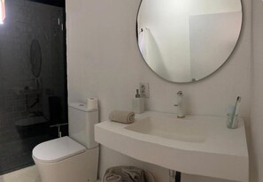Ein Badezimmer mit Toilette, Waschbecken und Spiegel.