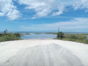 A coastal road leading to a beach with a clear sky and calm waters. - Keaton Beach Lodge, serene, private parking for several towing vehicles & boats (Perry)