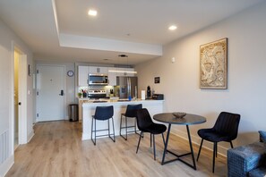 Una cucina moderna con isola centrale, sgabelli da bar e tavolo da pranzo.