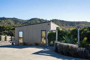 Un bâtiment moderne doté d’un toit plat, de grandes fenêtres et d’une allée gravillonnée.