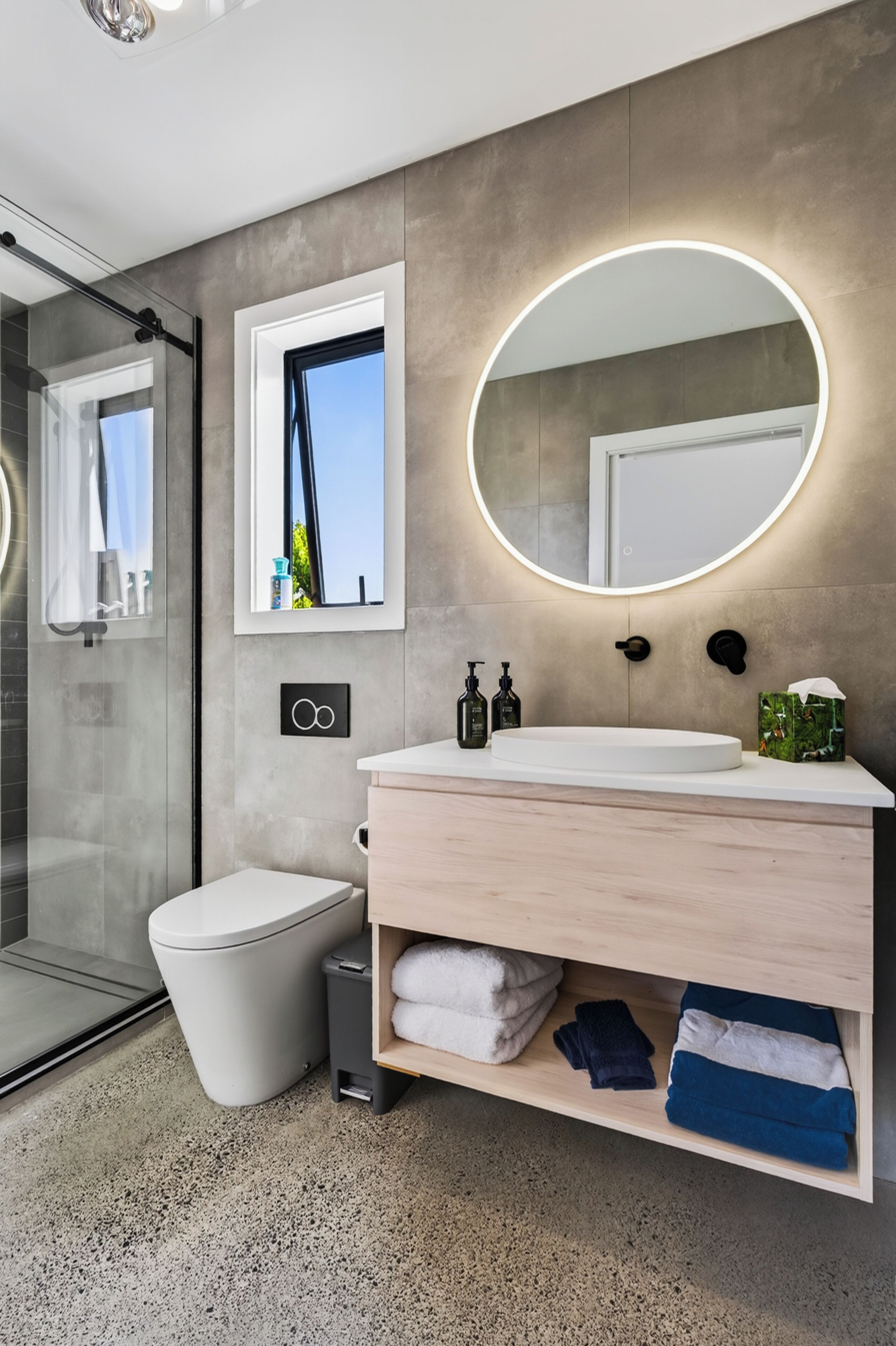 Une salle de bain moderne avec des toilettes, un lavabo et un miroir.