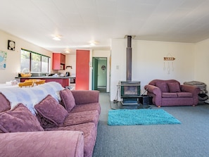 Ein gemütliches Wohnzimmer mit einer Couch, einem Teppich und einem Kamin.