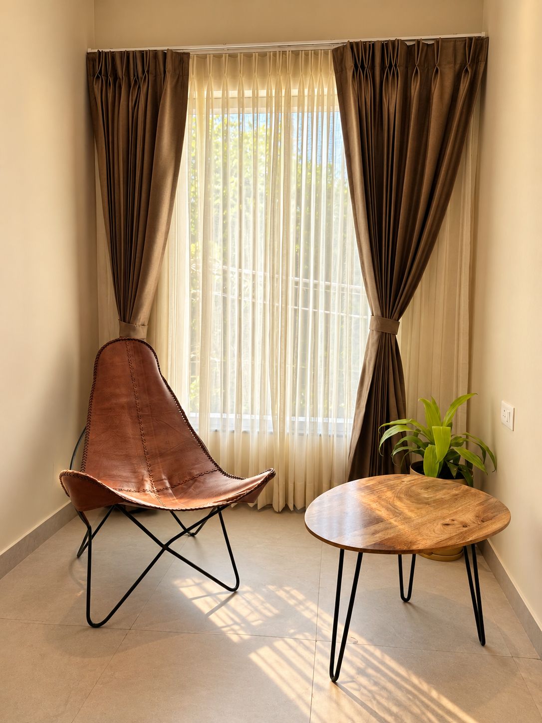A room with a single leather chair, a wooden table, and a potted plant.