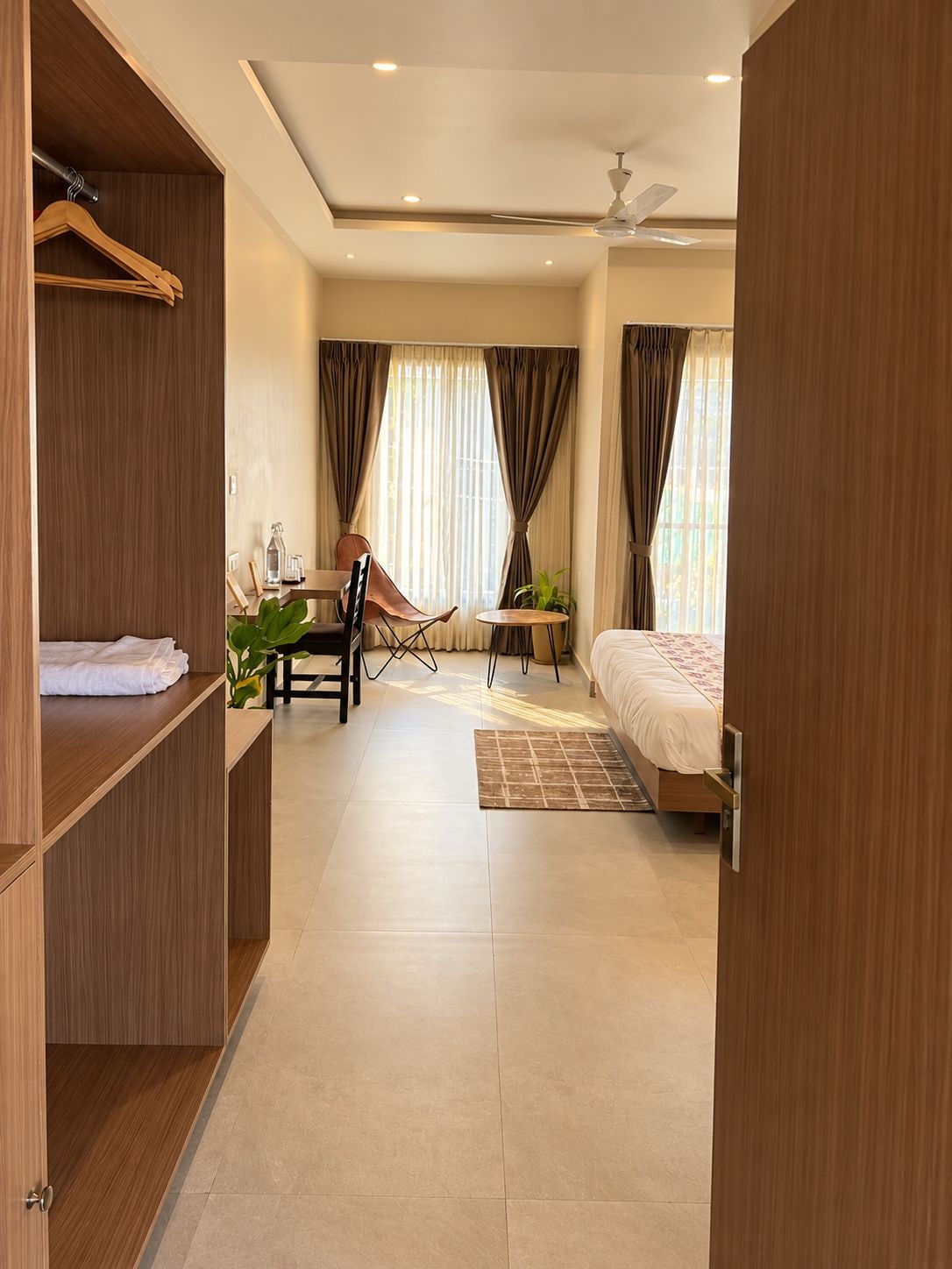 A modern bedroom with a bed, a desk, a chair, and a wardrobe.
