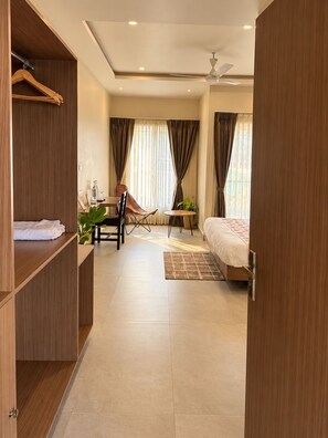 A modern bedroom with a bed, a desk, a chair, and a wardrobe. - ONE37 HOUSE (Udaipur)