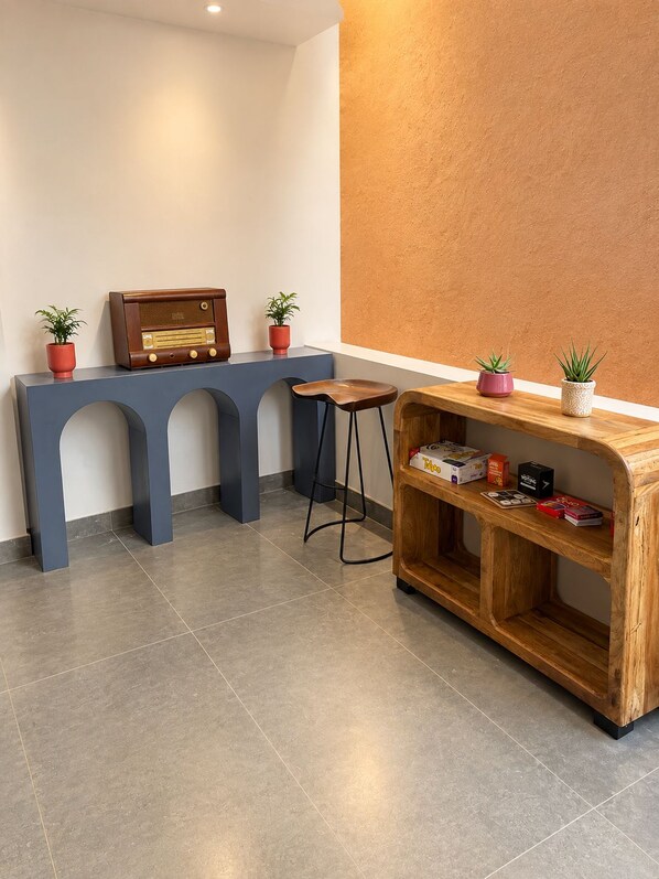 A modern interior with a blue console table, a wooden sideboard, and a small stool.