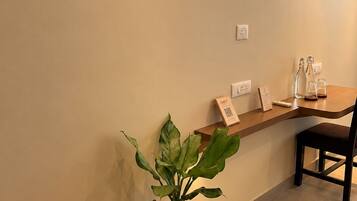 A reception area with a potted plant, a wooden counter, and a chair.