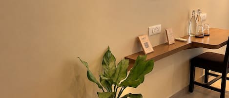 Un área de recepción con una planta en maceta, una barra de madera y una silla.