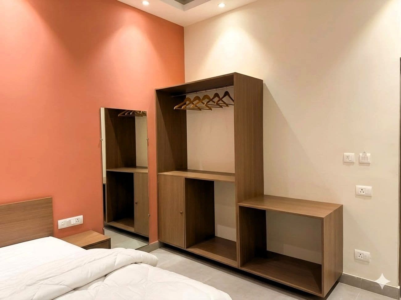 A bedroom with a bed, a wardrobe, and a bedside table.