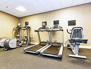 A fitness room with treadmills, elliptical machines, and a stationary bike. - Cozy 1-bedroom apartment Downtown Dallas (Dallas)