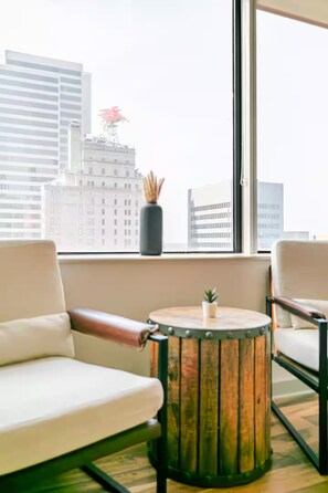 A modern room with a large window, a round wooden table, and two white chairs. - Cozy 1-bedroom apartment Downtown Dallas (Dallas)