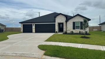 A two-story house with a garage, a well-maintained lawn, and a driveway.