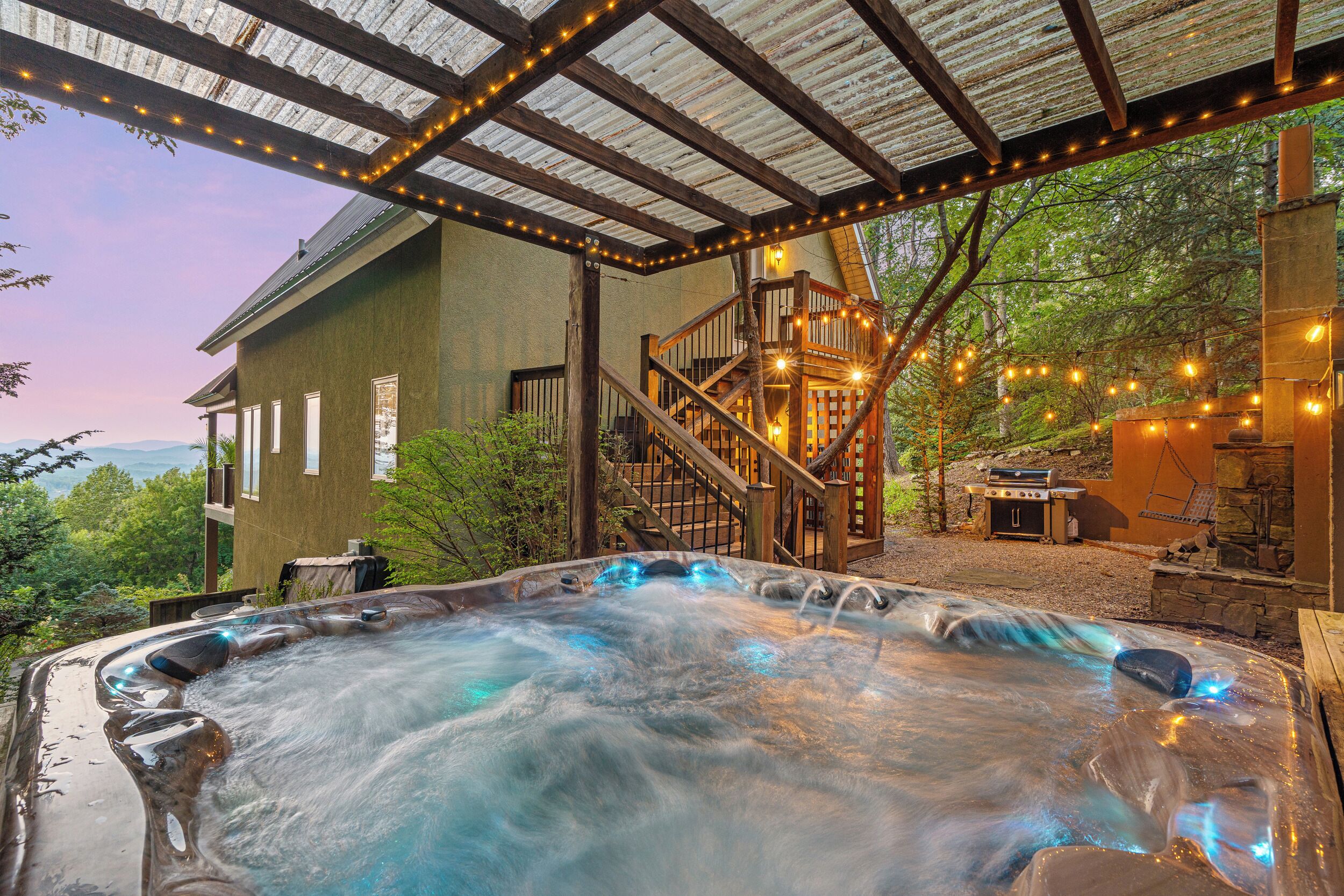 A hot tub with a wooden deck and a staircase leading to a wooden deck area.