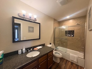 Un bagno con lavandino, WC e cabina doccia in vetro.