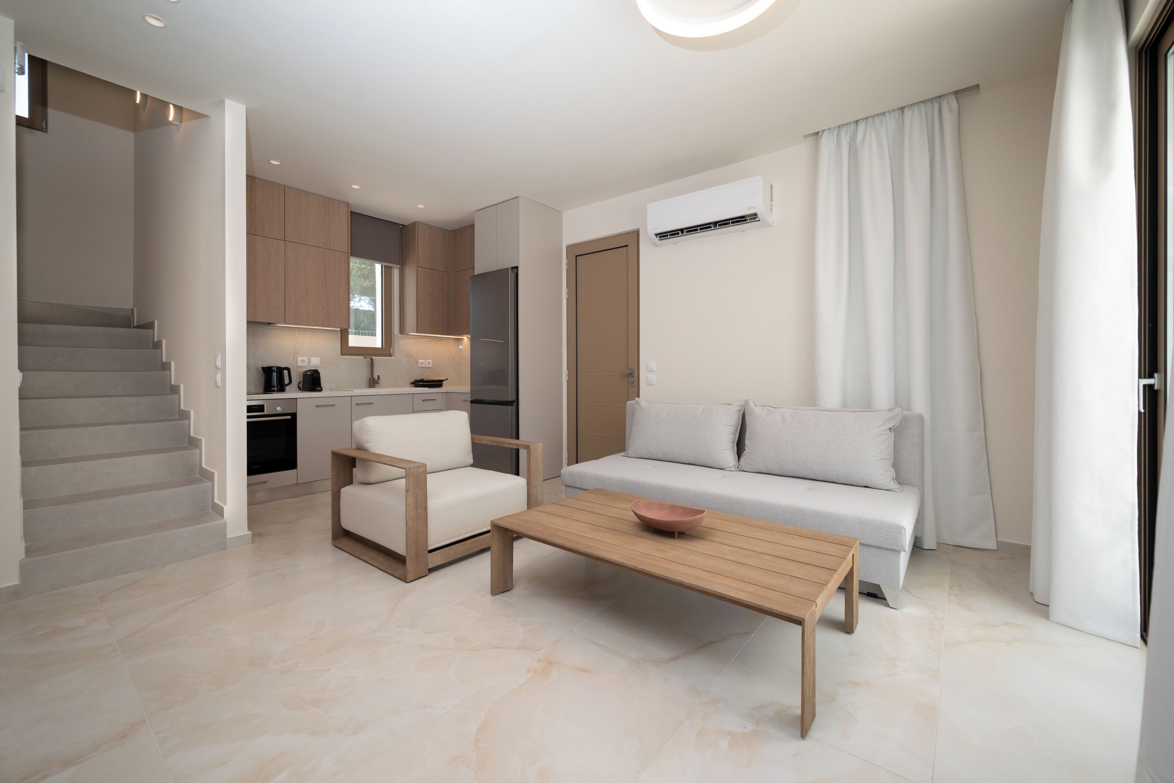 Een modern appartement met een woonruimte, keuken en trap.