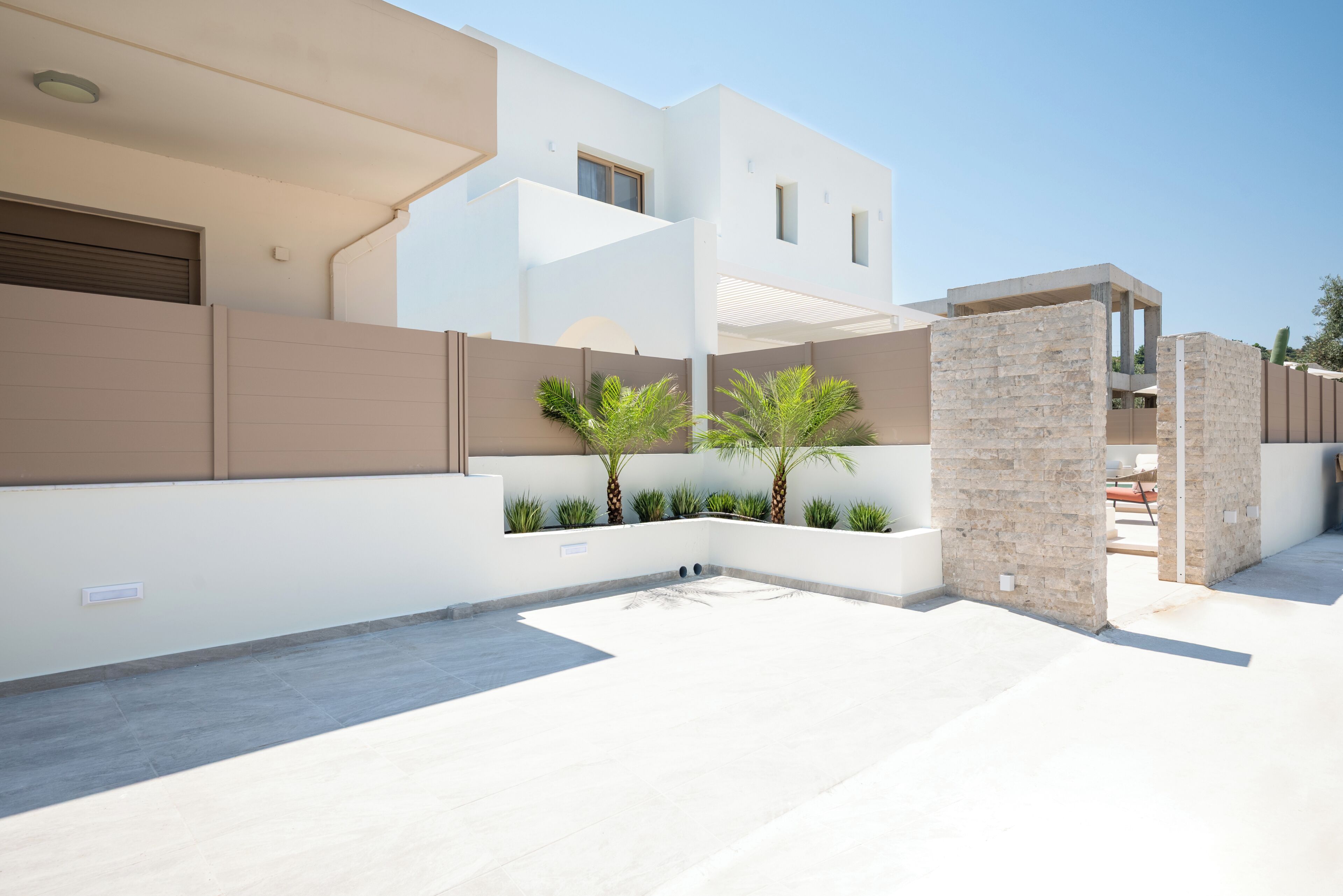 A modern two-story building with a flat roof, large windows, and a minimalist design.