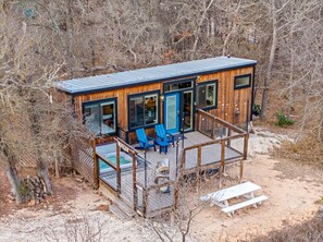 Une cabane en bois dotée d’une terrasse, d’un espace salon extérieur et d’une piscine.