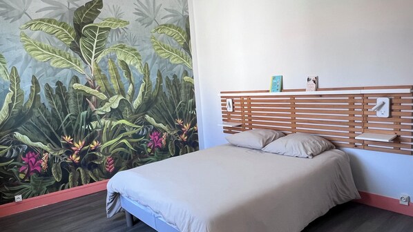 A bedroom with a bed, a wall-mounted shelf, and a power outlet. - Vrbo Property (La Tranche-sur-Mer)